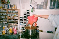 a person pouring paint into a pot