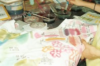 a woman painting on a tee shirt